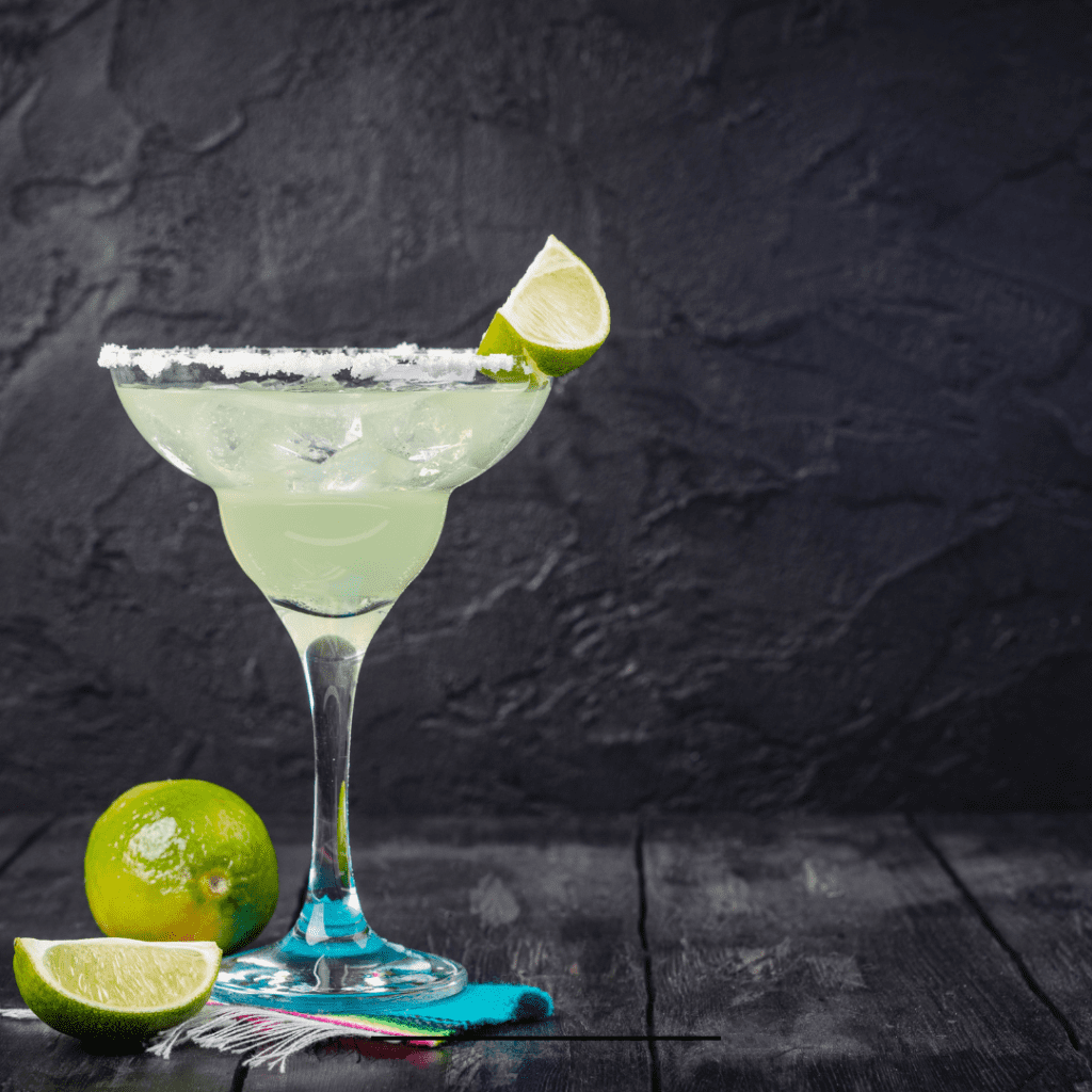 sour mix margarita topped with a slice of lemon and salted rim on a black background
