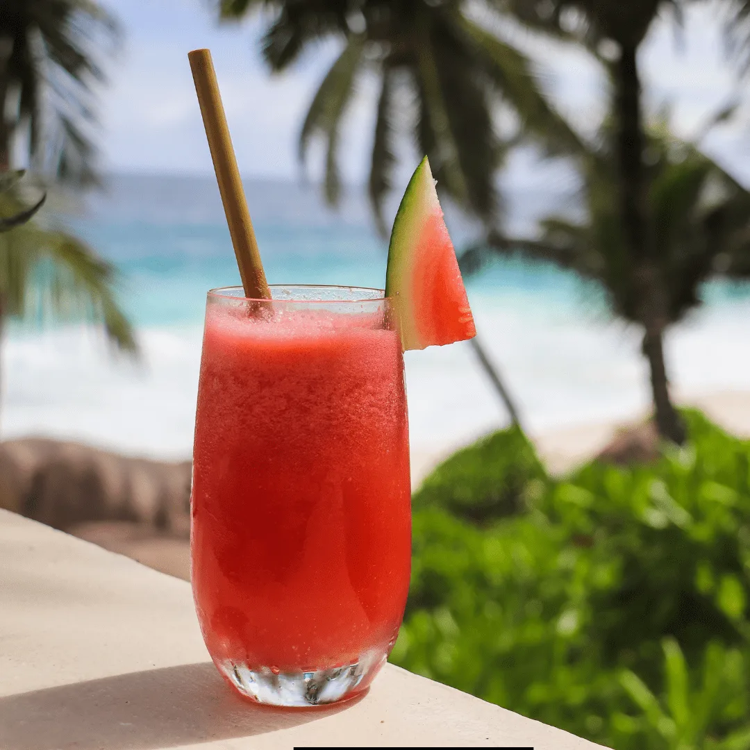 Smoothie King Watermelon Xtreme Drink with a watermelon slice on a beach