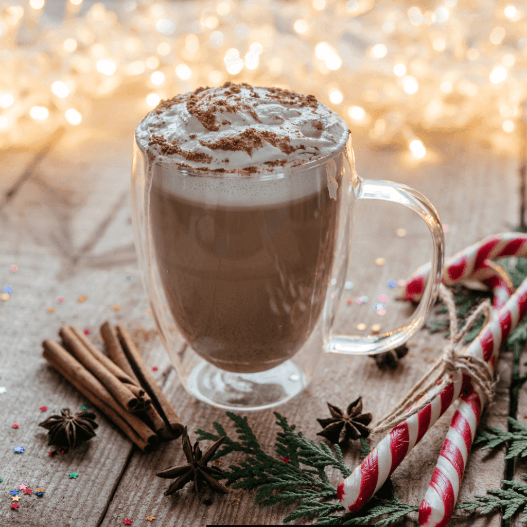 Ryze Mushroom Hot Cocoa with froth on top and candy cane and spices beside, best for autumn and winter. 